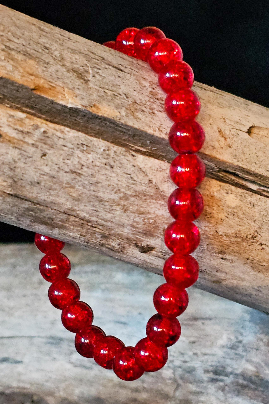 Red beaded bracelet on a wooden log