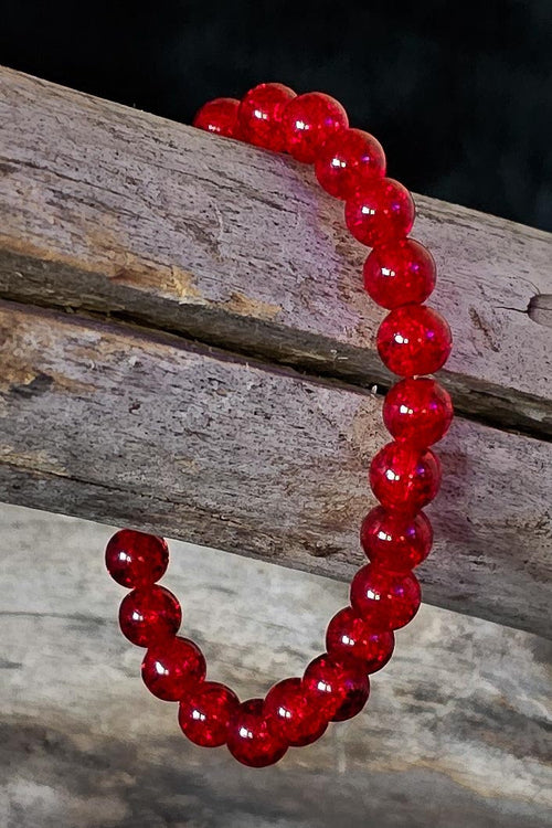 Red beaded bracelet on a wooden surface