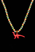 Necklace with colorful beads and a pink dinosaur charm on a black background