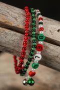 Three beaded bracelets in red, green, and white with the letters 'BELLS' and 3 tiny jingle bells on a wooden surface.