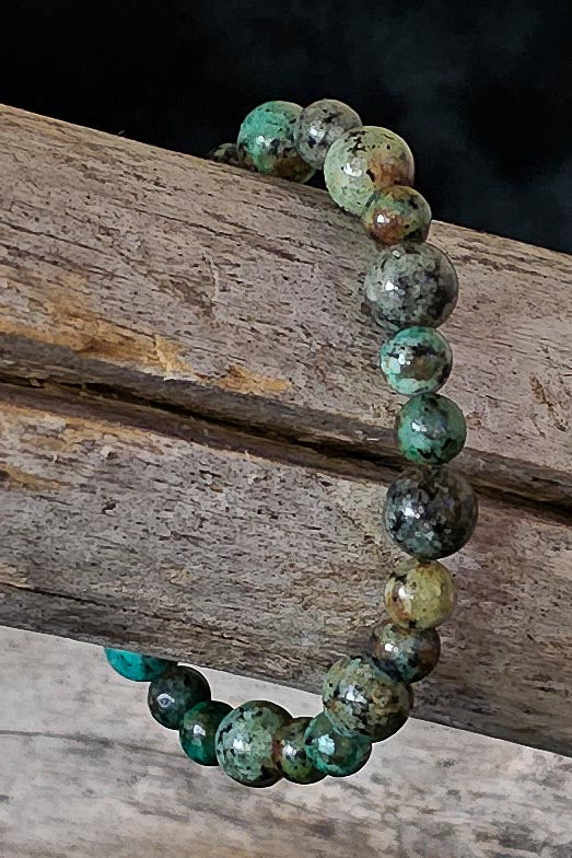 Benjamin handcrafted African turquoise jasper green & black beaded bracelet on a wooden surface — Amelia Heir Art