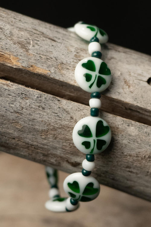 Blake handcrafted white & green beaded bracelet with shamrock & heart beads on a wooden surface — Amelia Heir Art