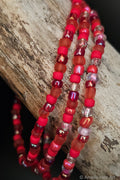 Red and clear beaded bracelets on a wooden surface