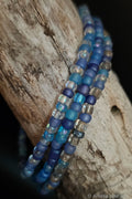 Blue and clear beaded bracelets on a wooden surface
