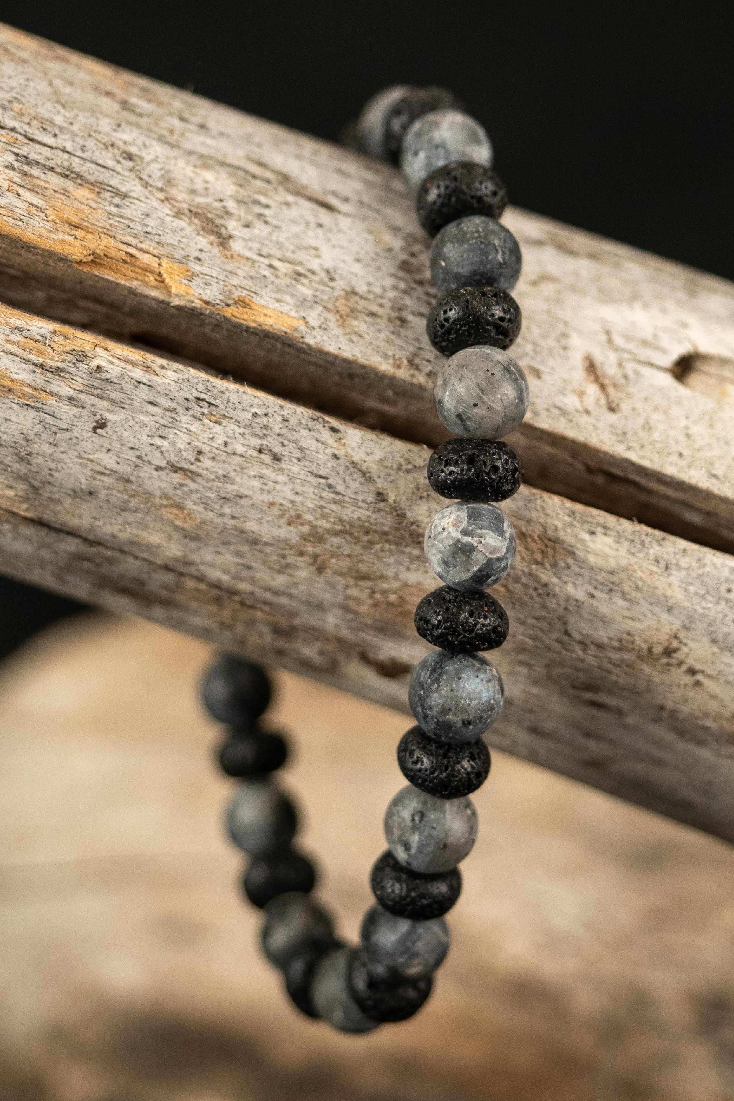 Beaded bracelet with black and gray beads on a wooden branch