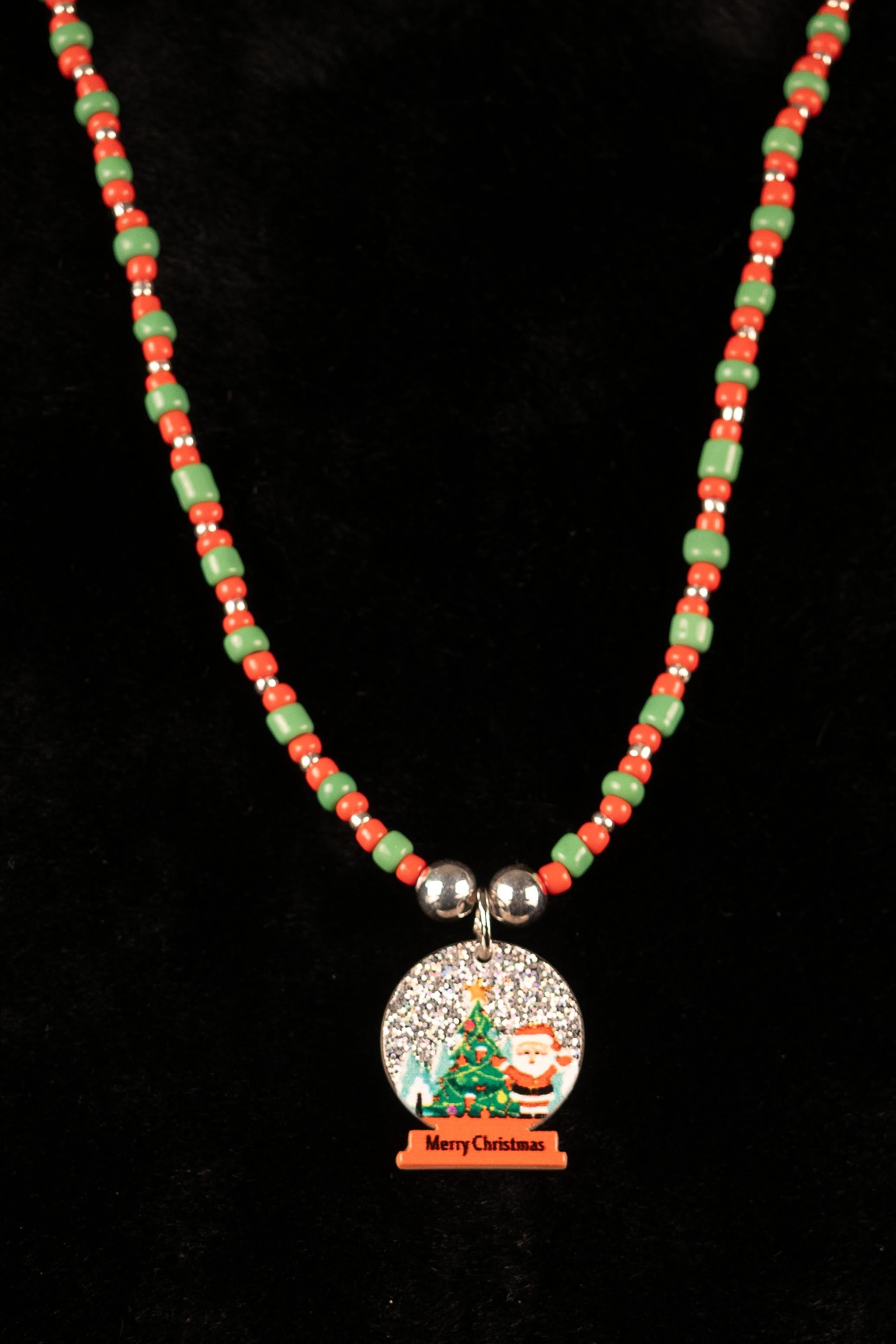 Necklace with a Christmas-themed snow globe pendant on a black background