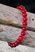 Red beaded bracelet on a wooden surface