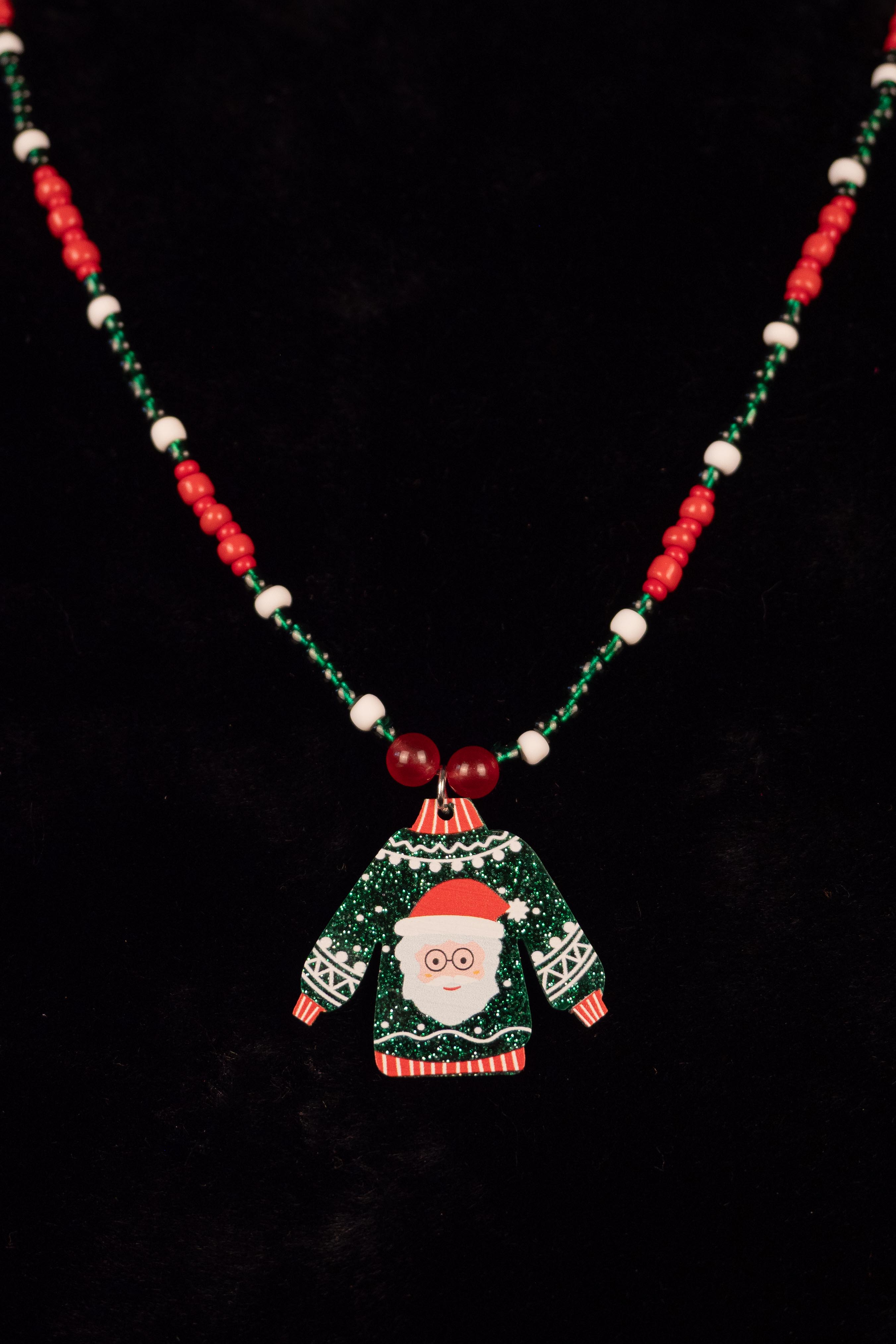 Christmas necklace with a Santa Claus sweater pendant on a black background