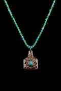 Necklace with turquoise beads and chap pendant on a black background