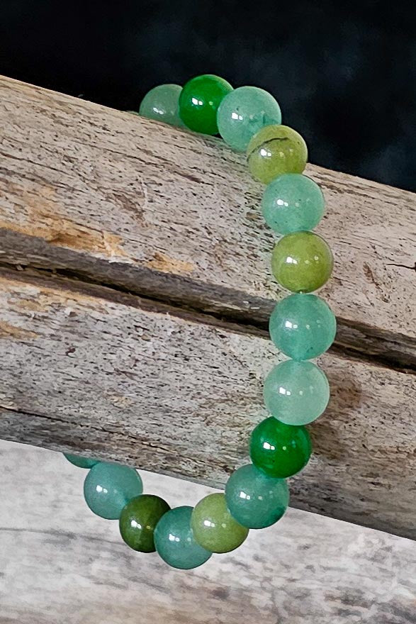 Multi green beaded bracelet on a wooden surface