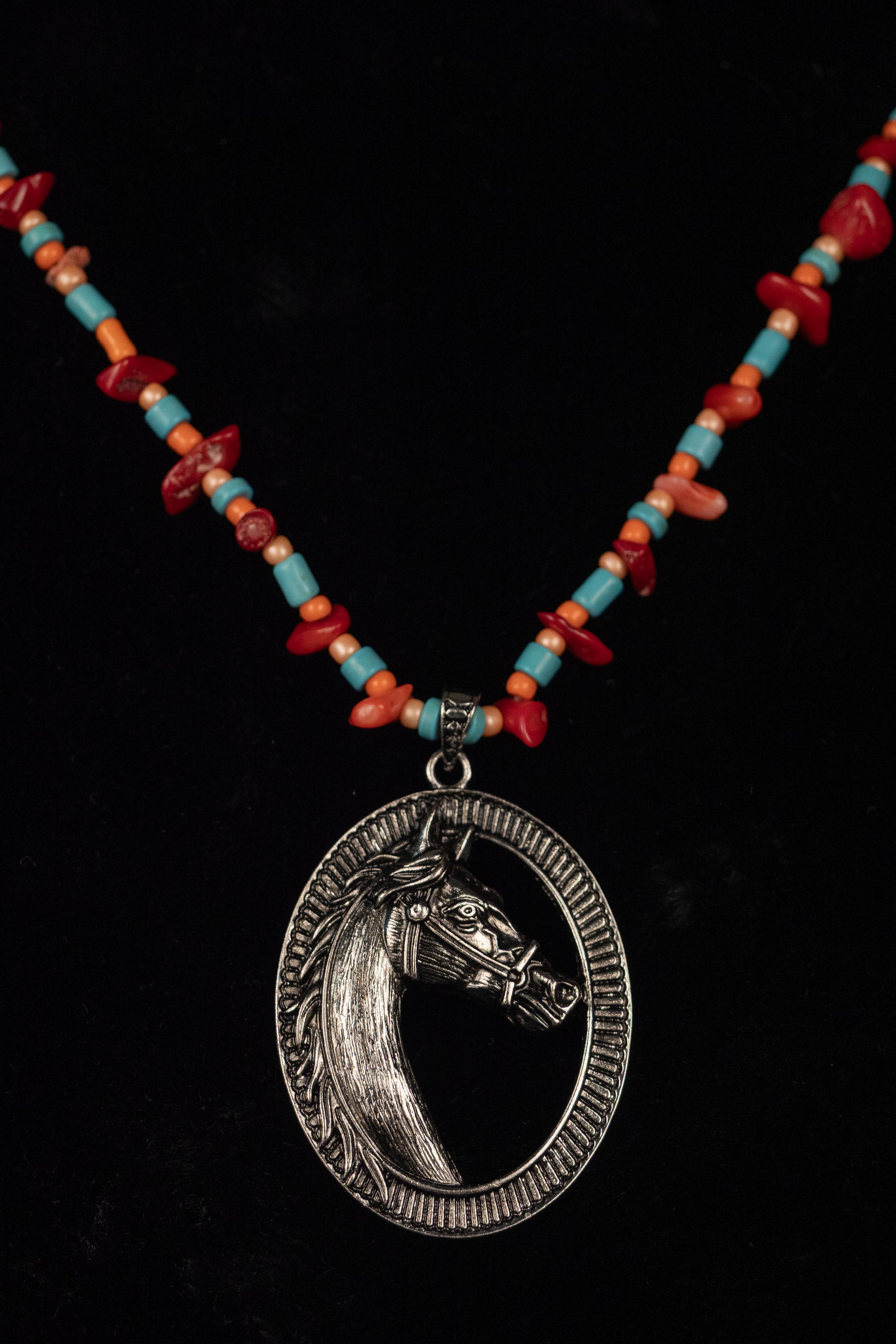 Necklace with a horse pendant and colorful beads on a black background