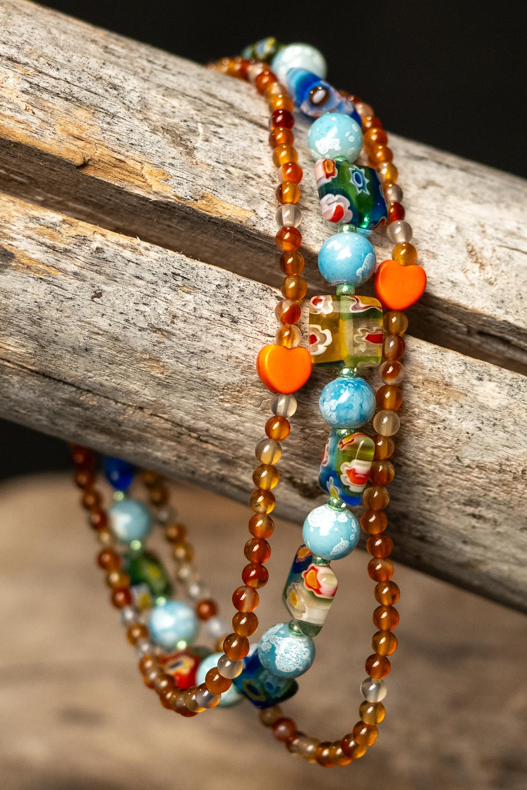 Colorful orange and blue beaded bracelets on a wooden surface