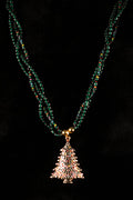 Necklace with three beaded strands and a Christmas tree pendant on a black background