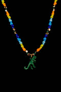 Necklace with colorful beads and a green dinosaur pendant on a black background