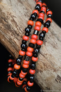 Necklace with black and pink beads on a wooden surface