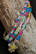Colorful beaded bracelets with a star-shaped charm on a wooden surface