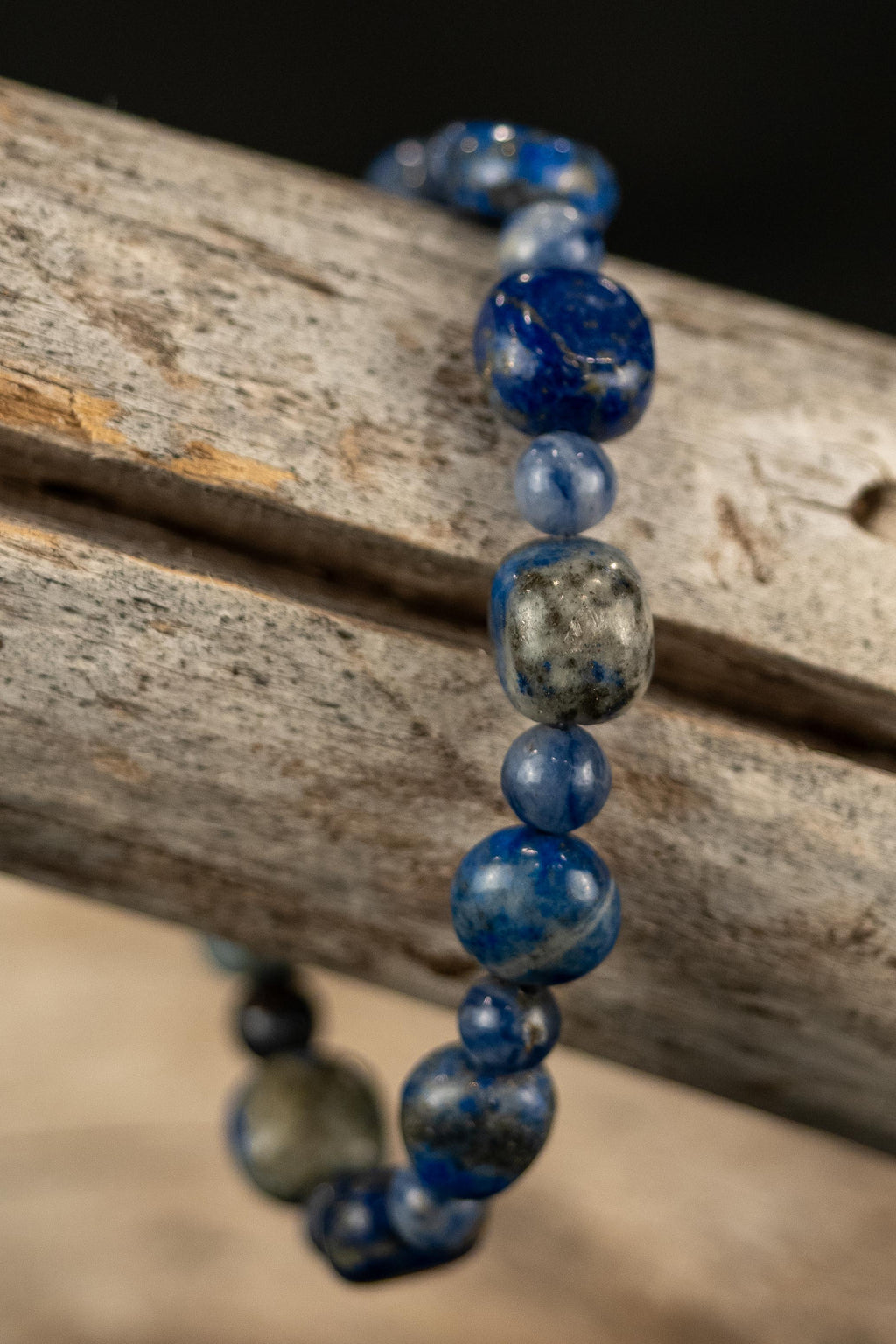 Jack handcrafted Lapis & Blue Sodalite gemstone beaded bracelet on a wooden surface — Amelia Heir Art