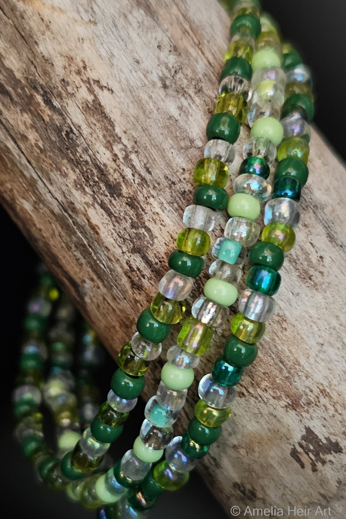Green and clear beaded bracelets on a wooden surface