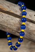 Blue and yellow beaded bracelet on a wooden surface