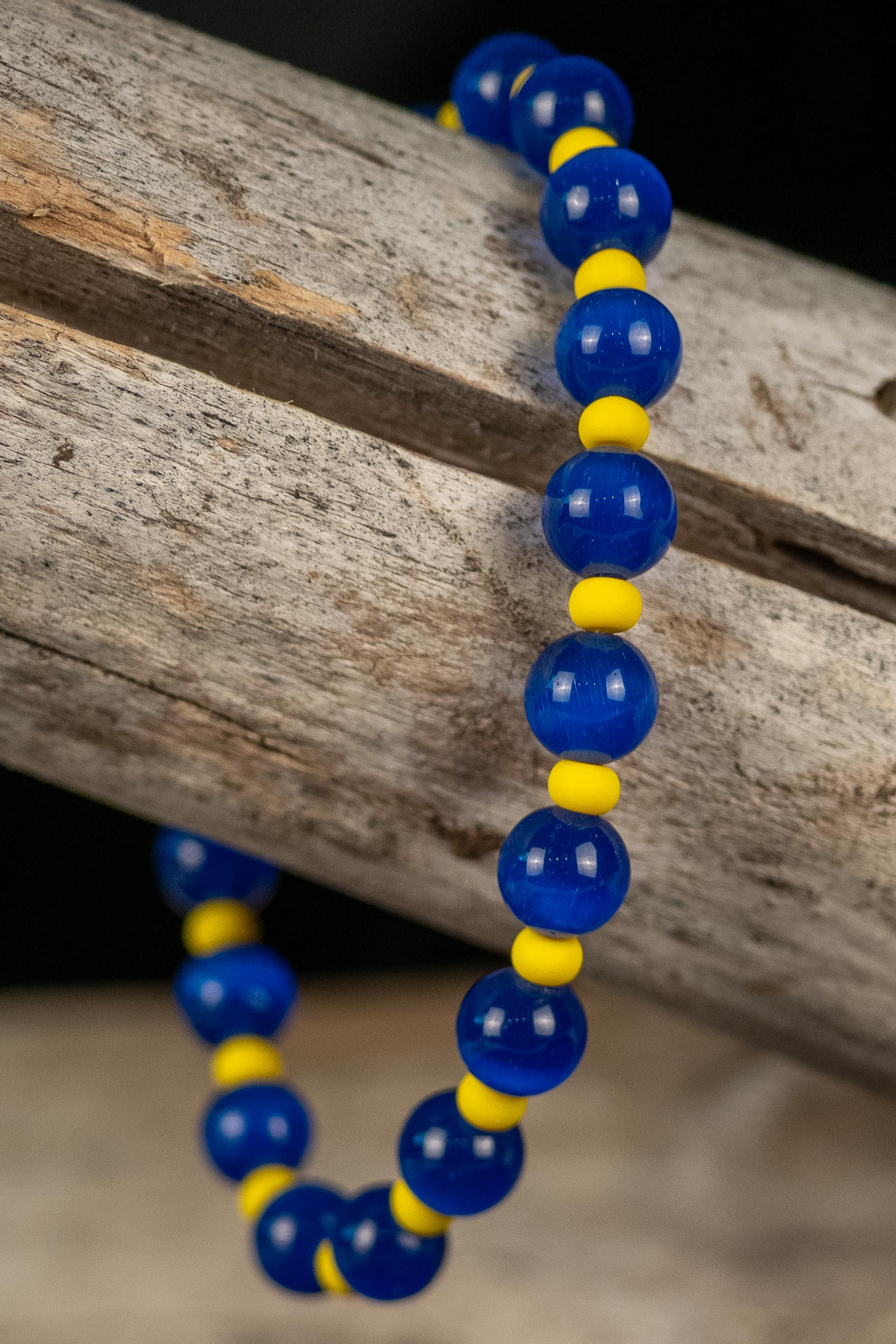 Blue and yellow beaded bracelet on a wooden surface