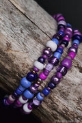 Stack of cool colorful beaded bracelets on a wooden surface