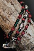 Three beaded bracelets with a silver hiking boot charm on a wooden surface