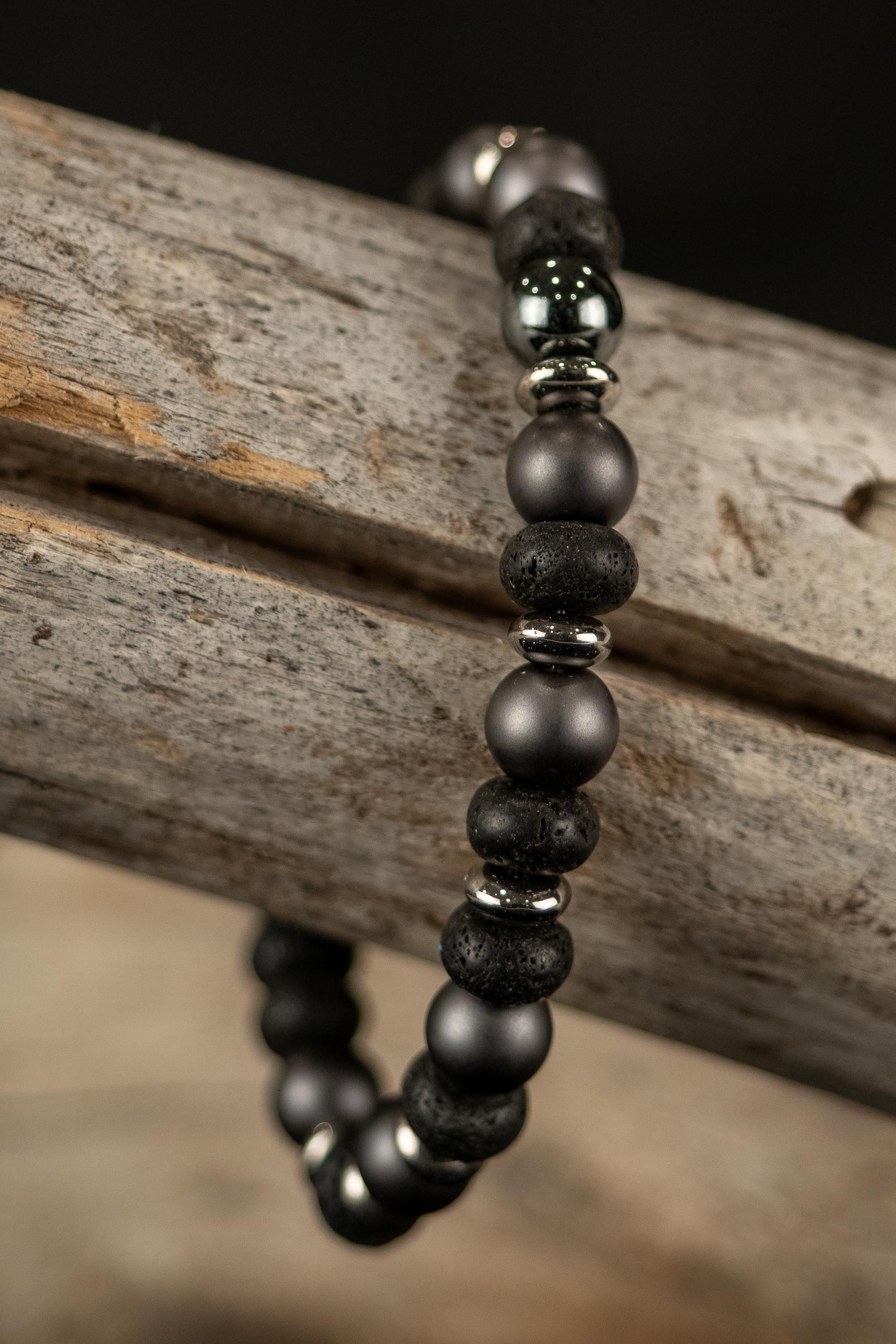 Black, gray, and silver beaded bracelet on a wooden surface