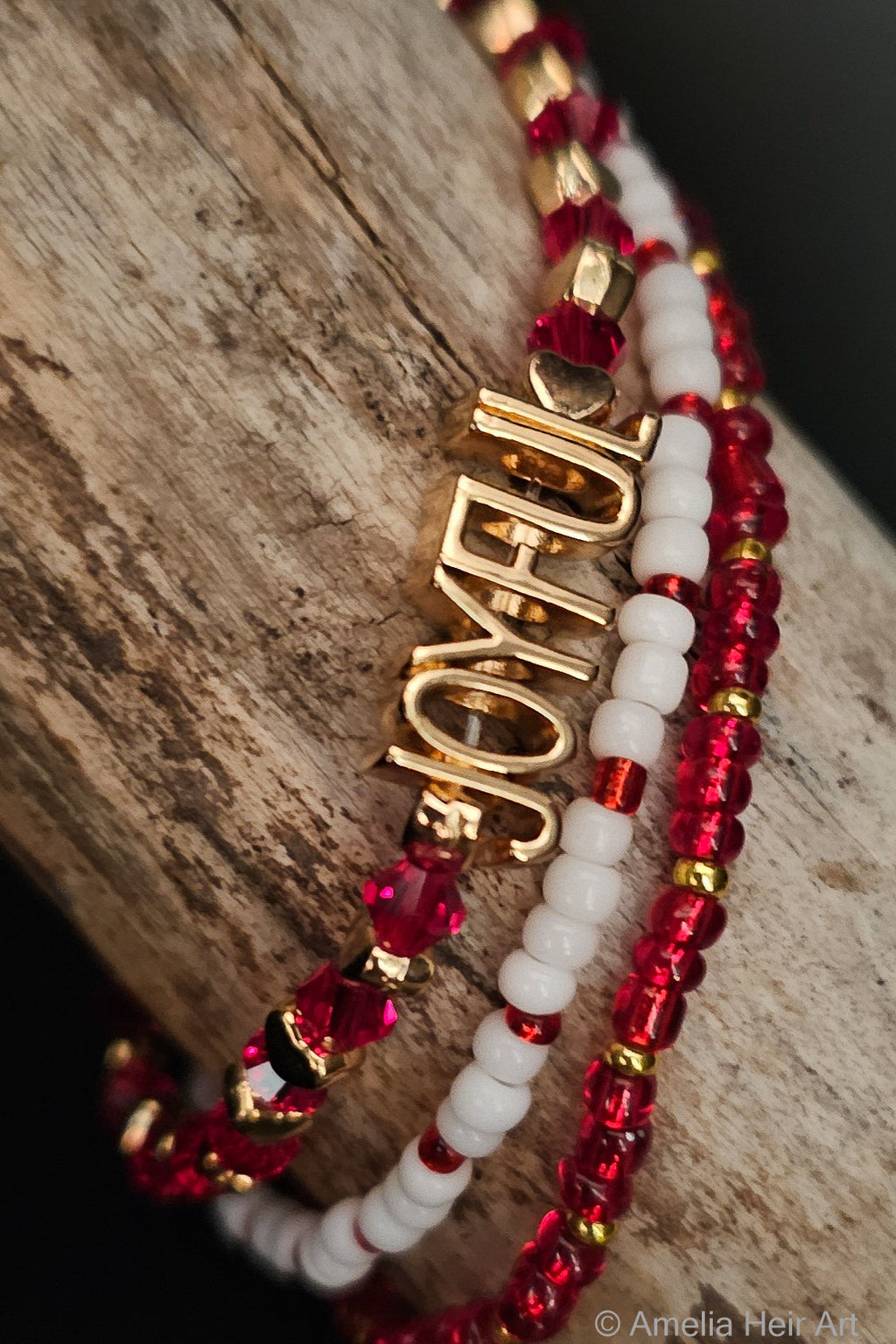 Joyful Heart handcrafted red, white & gold beaded bracelet set with gold heart charm on a wooden surface — Amelia Heir Art