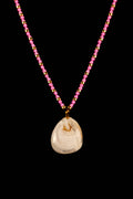 Necklace with a white stone pendant and pink bead chain on a black background