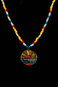 Necklace with a colorful bead chain and a round, multicolored pendant with a sunrise and water on a black background
