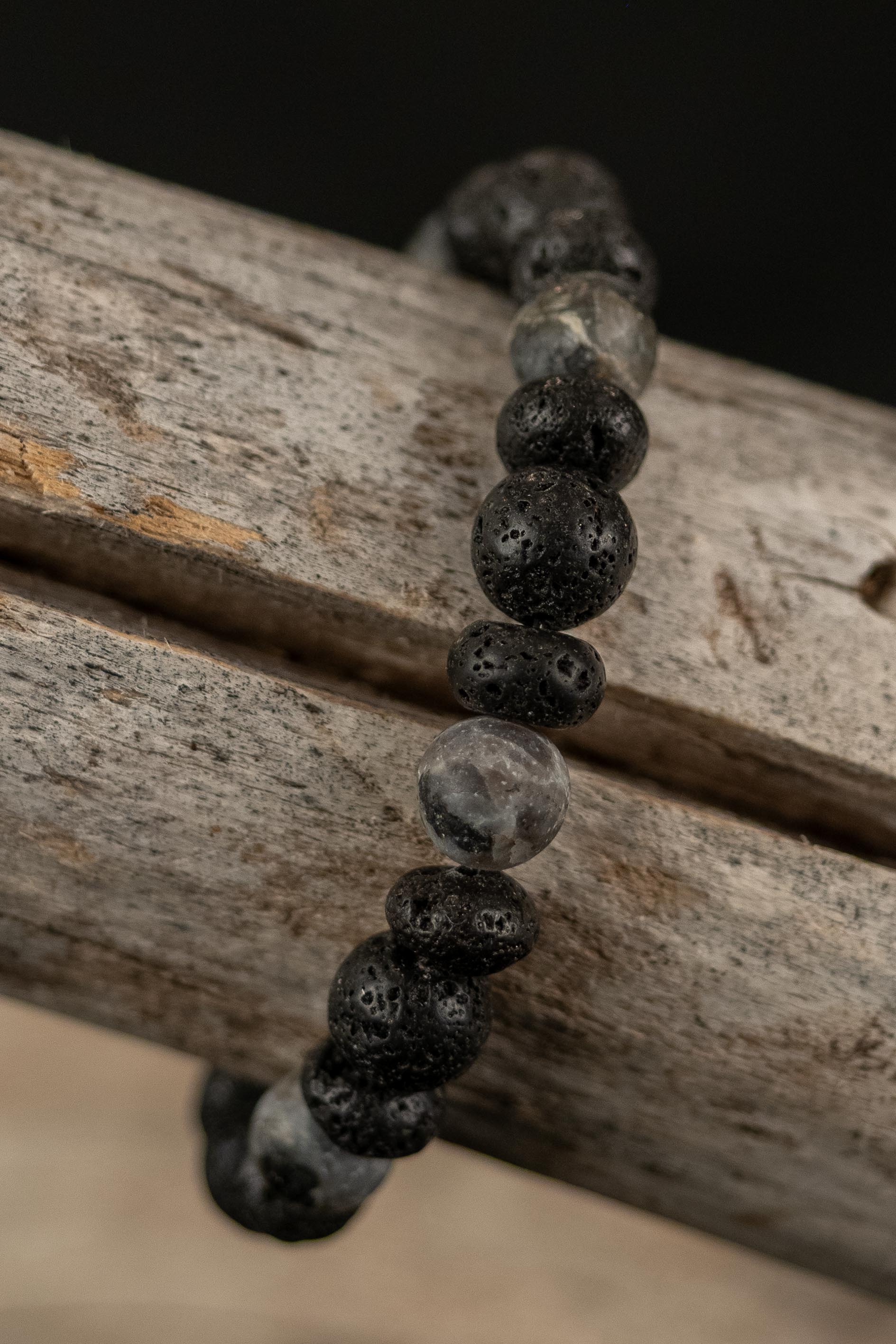 Bracelet with black and gray beads on a wooden surface