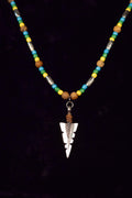 Necklace with beads and a silver arrowhead pendant on a black background
