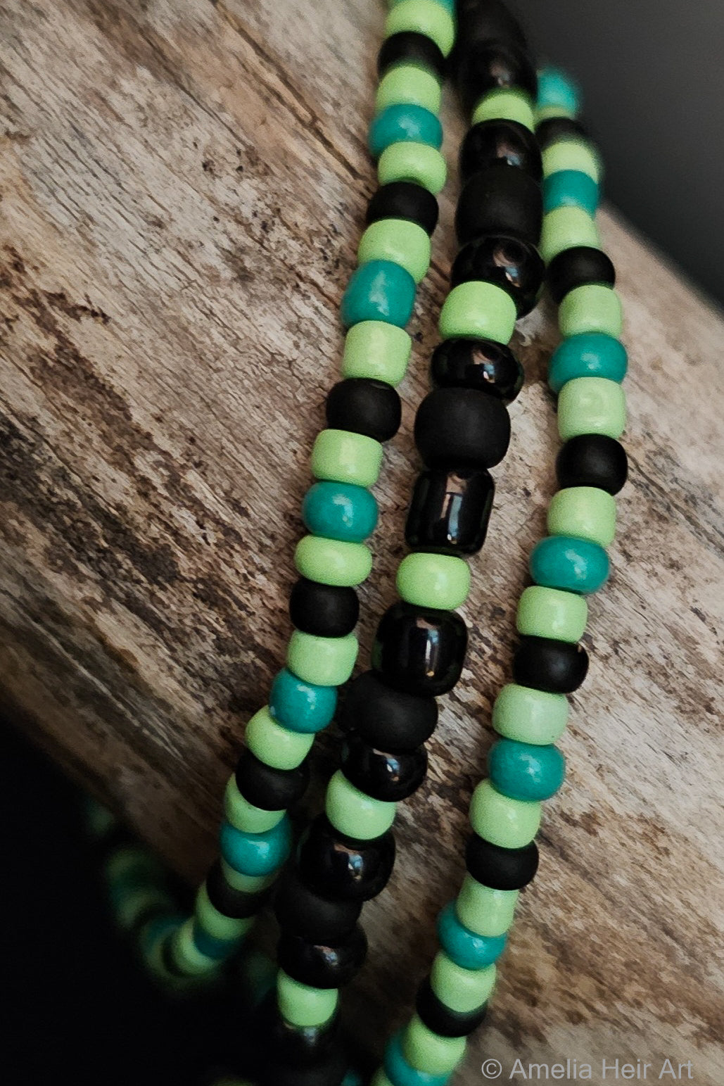 Necklace with green and beads on a wooden surface