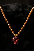 Necklace with multi-faceted red heart pendant on a black background