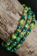 Green beaded bracelets on a wooden surface
