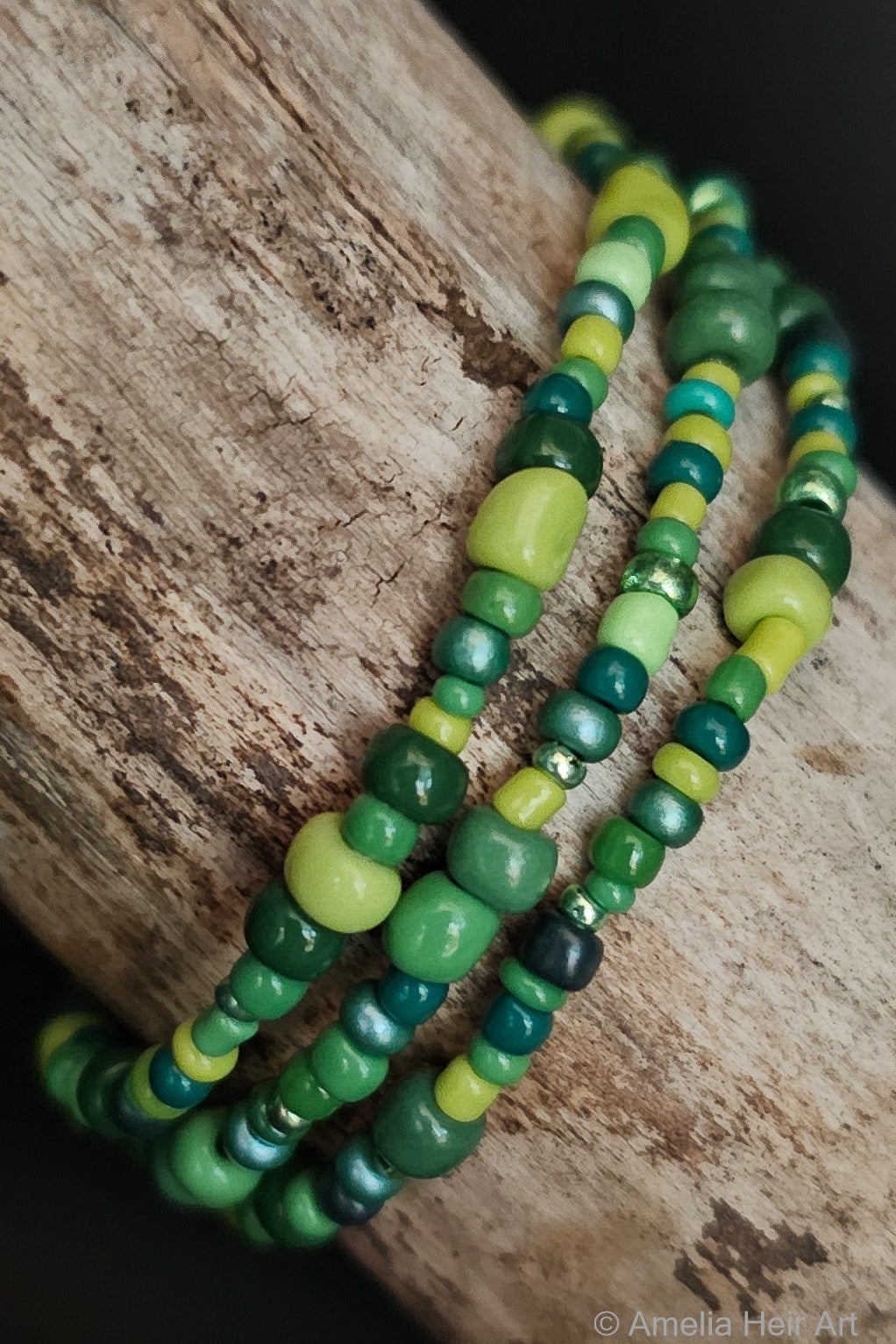 Green beaded bracelets on a wooden surface