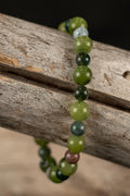 Beaded bracelet with green and brown beads on a wooden surface