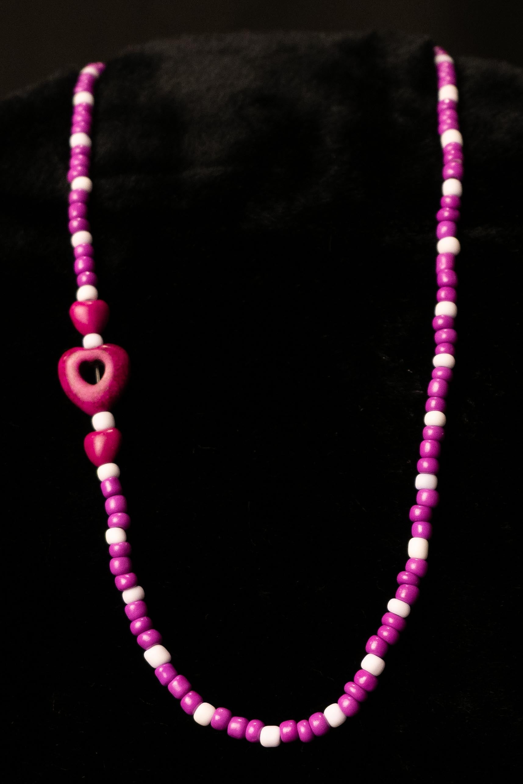 Necklace with purple beads on a black background