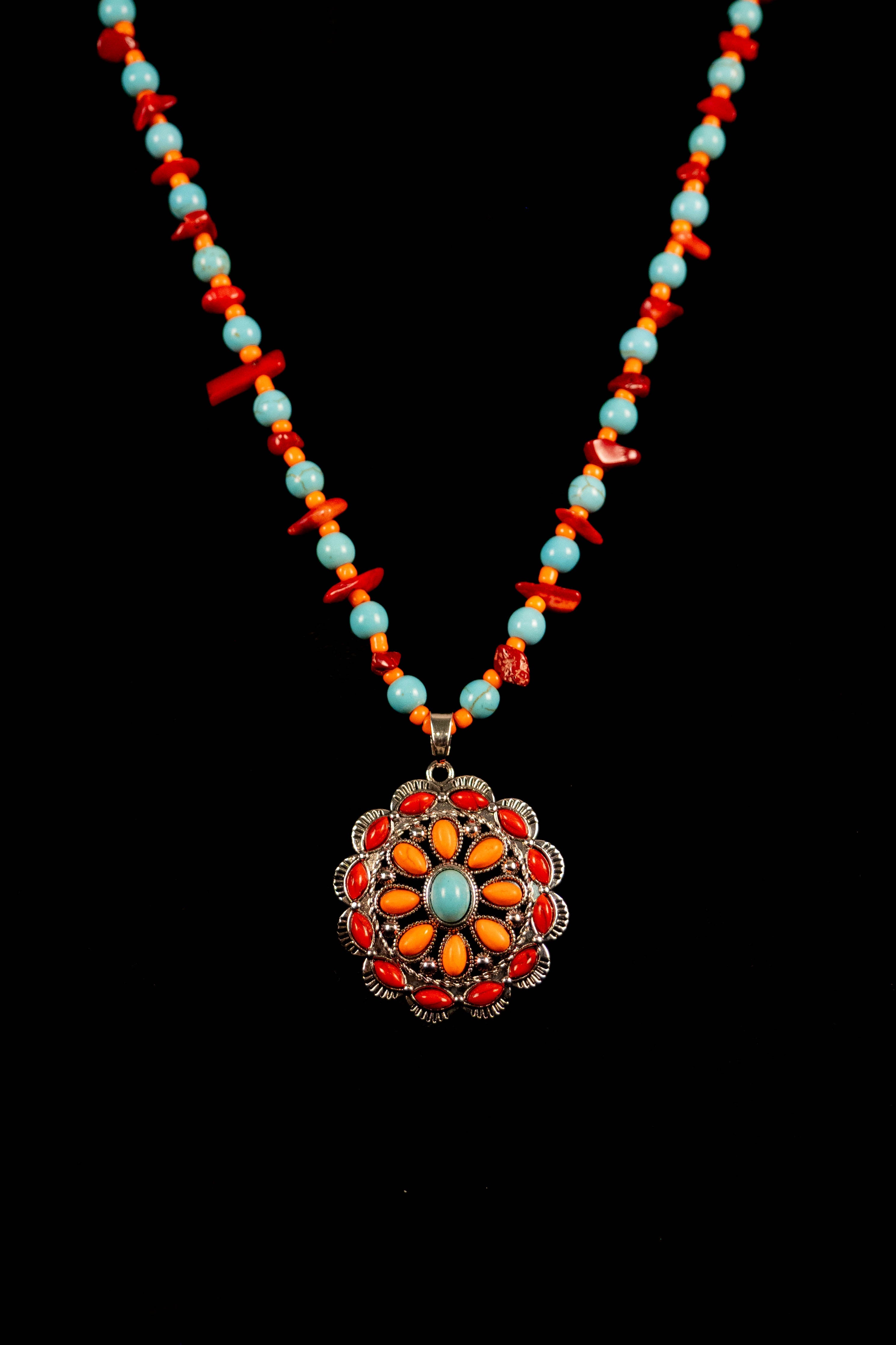 Necklace with colorful beads and a floral pendant on a black background