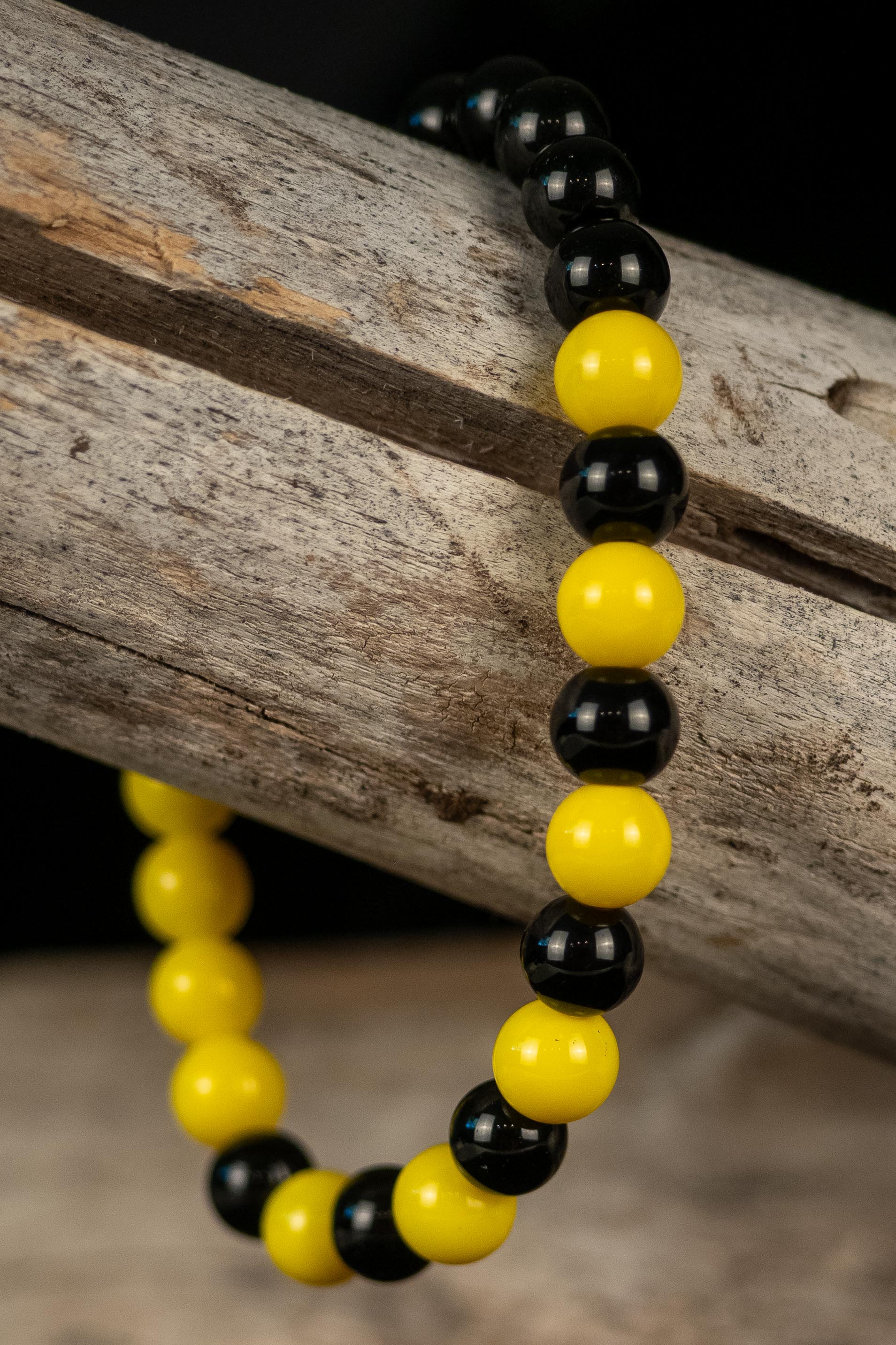 Black and yellow beaded bracelet on a wooden surface