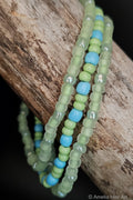 Green and blue beaded bracelets on a wooden surface