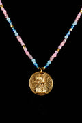 Necklace with a gold coin castle pendant and multicolored beads on a black background