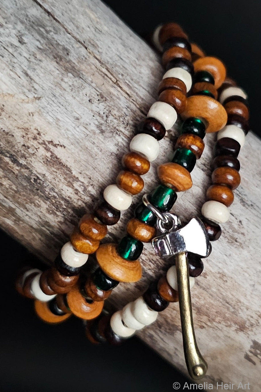 Wooden beaded bracelet with a metal axe charm on a wooden surface