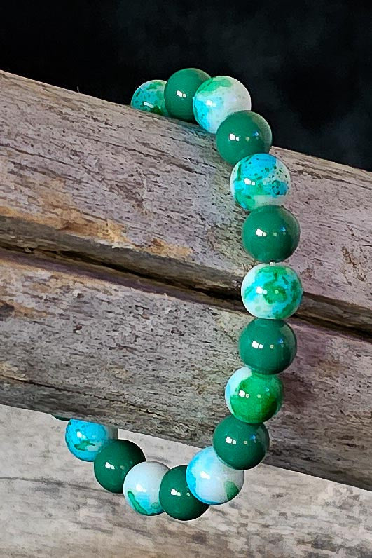 Green and blue beaded bracelet on a wooden surface