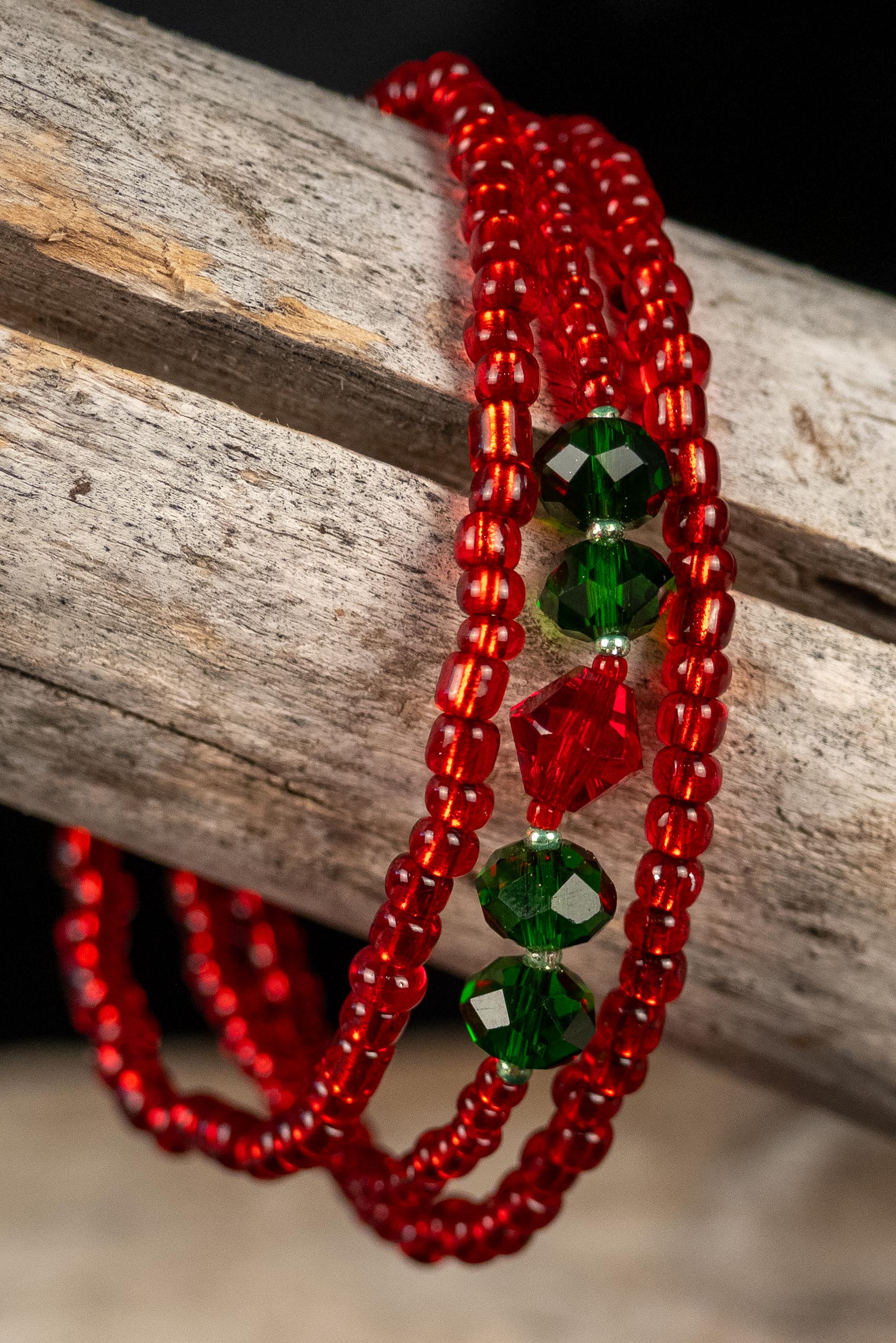 Red and green beaded bracelets on a wooden surface