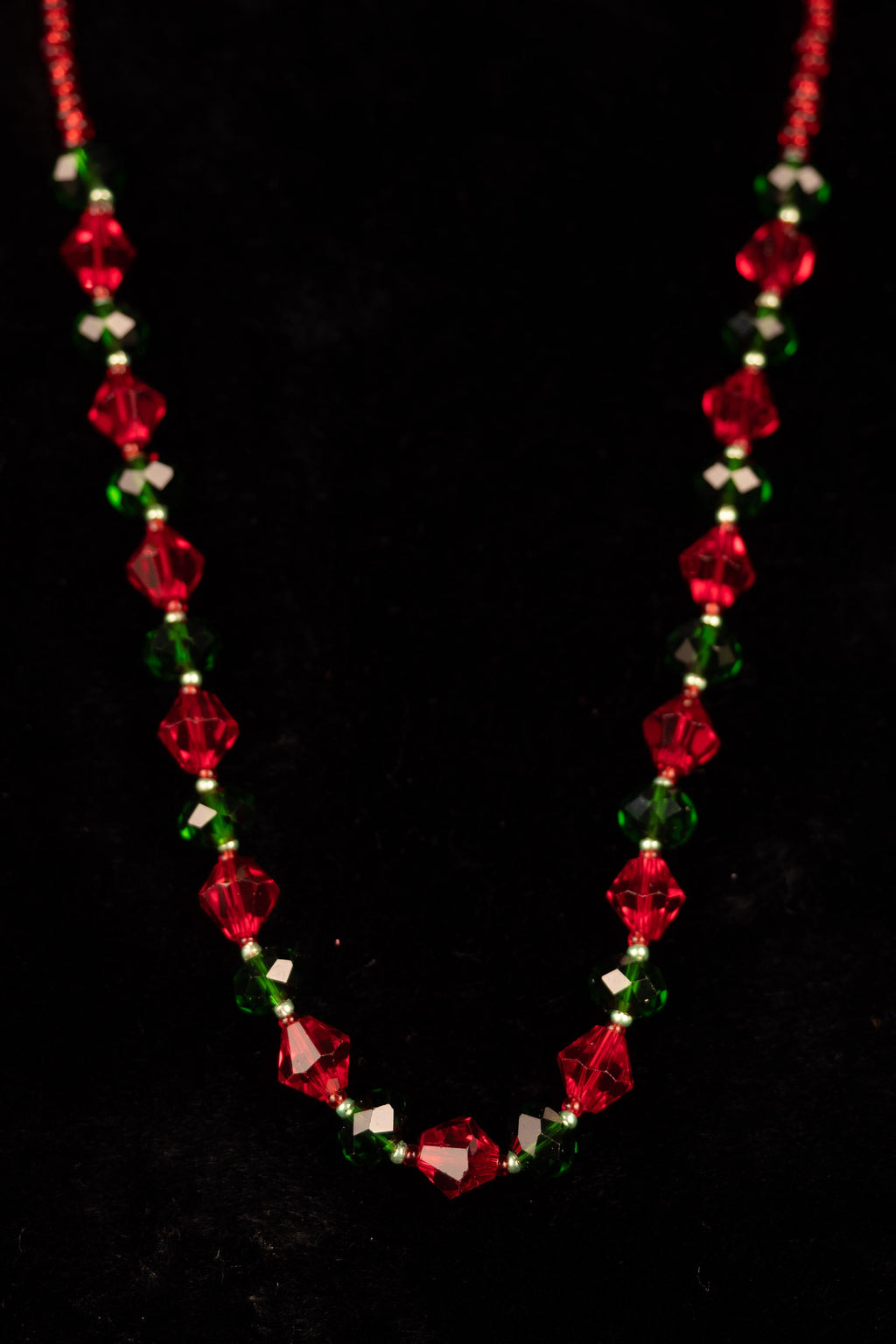 Necklace with red and green beads on a black background