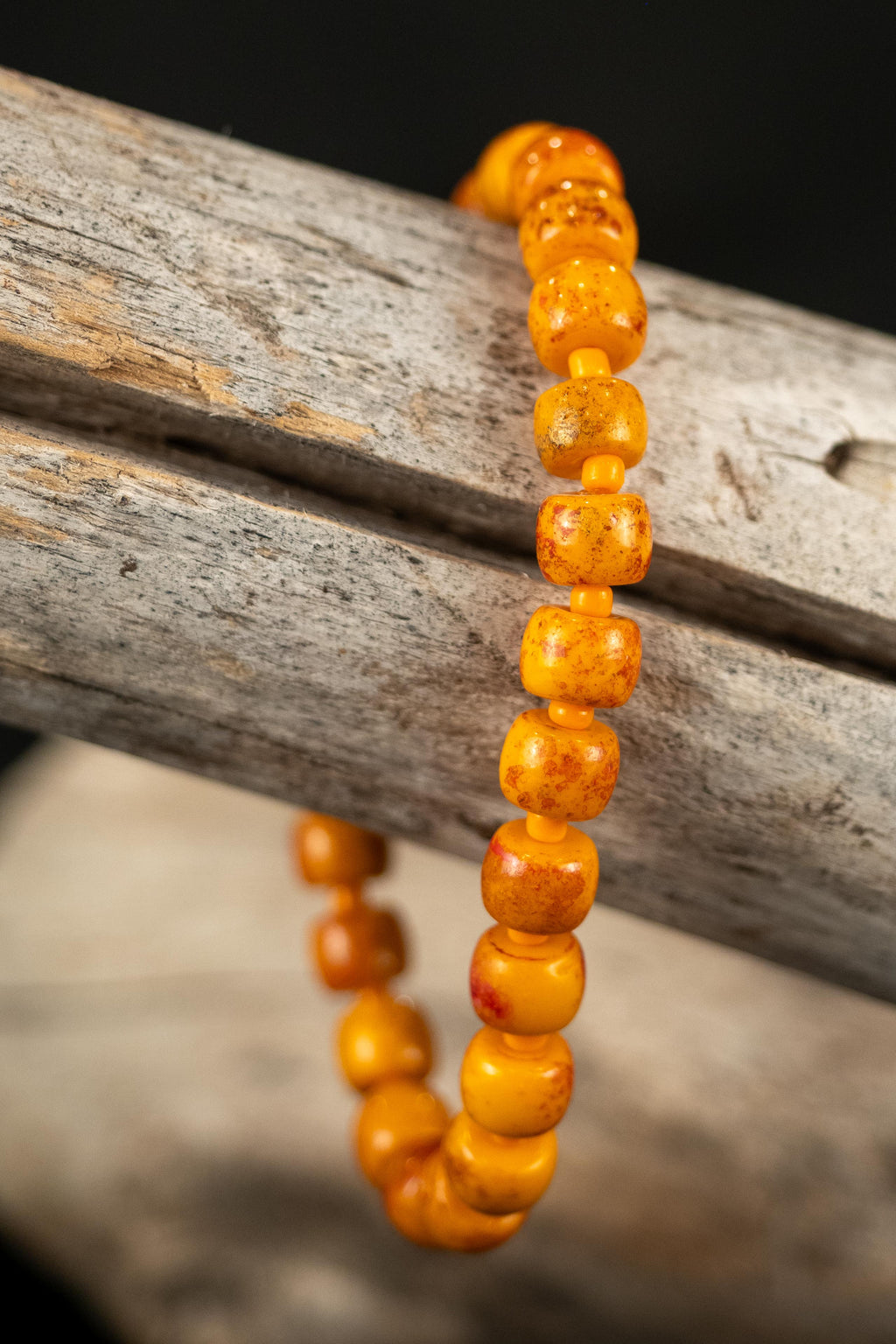 Oliver handcrafted vivid orange beaded bracelet on a wooden branch — Amelia Heir Art