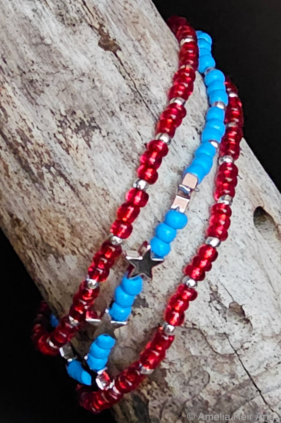 Power handcrafted red, white, blue & silver beaded bracelet set with star charm on a wooden surface — Amelia Heir Art