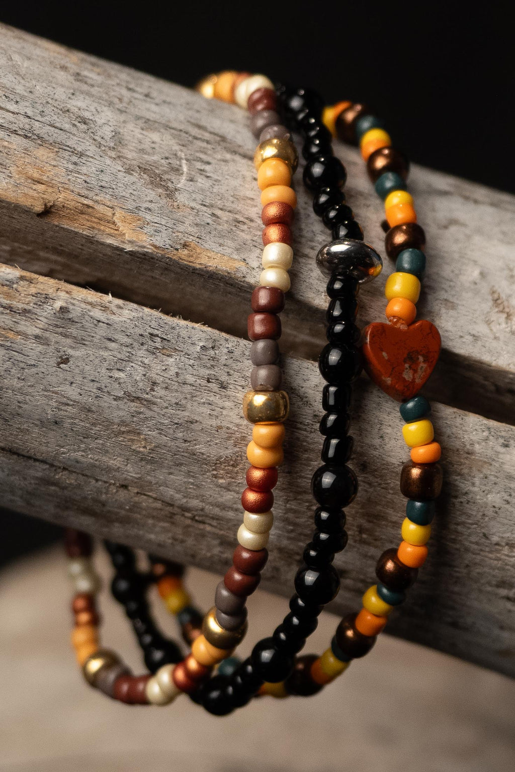 Priya handcrafted yellow orange green gold brown black and silver beaded bracelet set on a wooden surface — Amelia Heir Art