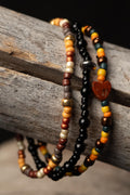 Stack autumn colored beads bracelets on a wooden surface